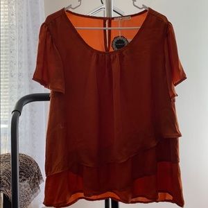 Woman’s burnt orange top